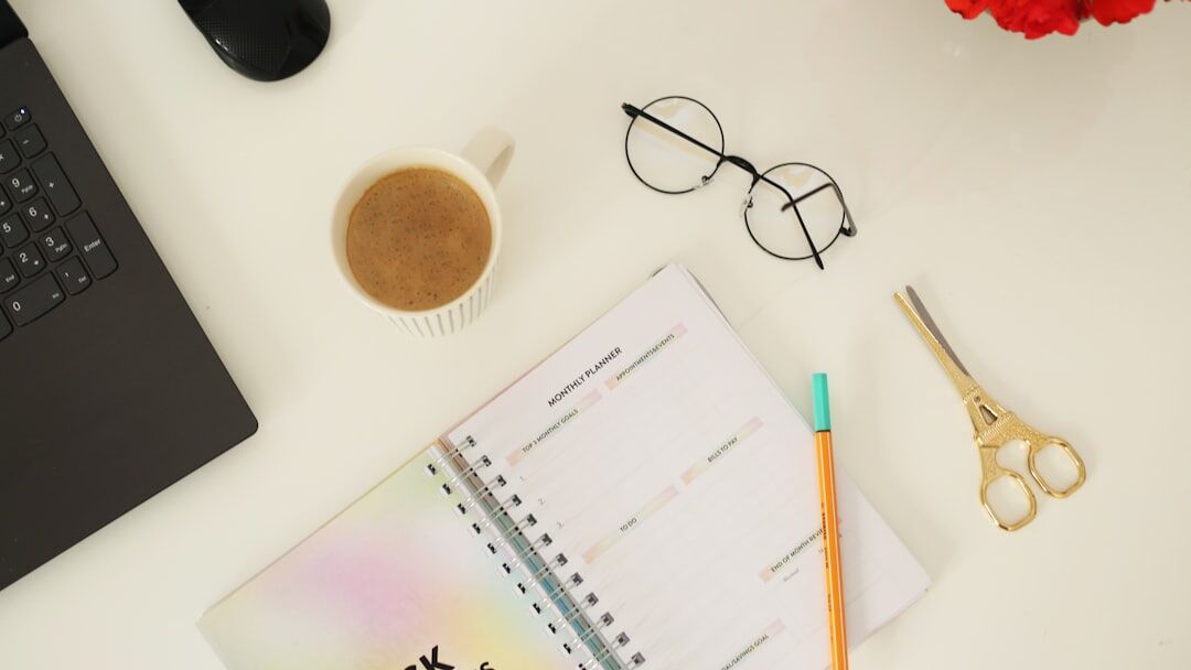 Analog clock beside a planner and pen on a desk