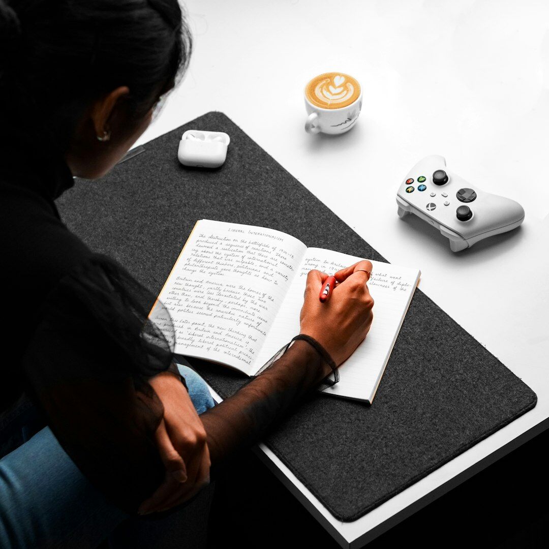 Brazilian mentor writing notes while explaining a concept at a desk